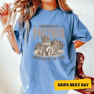 a woman wearing a t - shirt that says meowy partner wishes in the