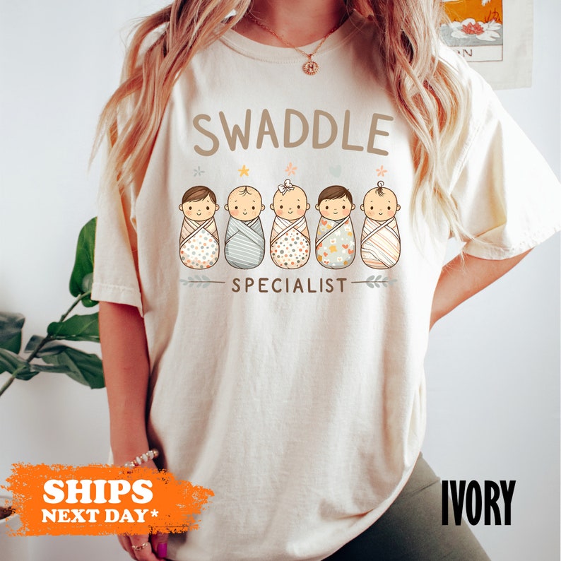 a woman wearing a swaddle special t - shirt