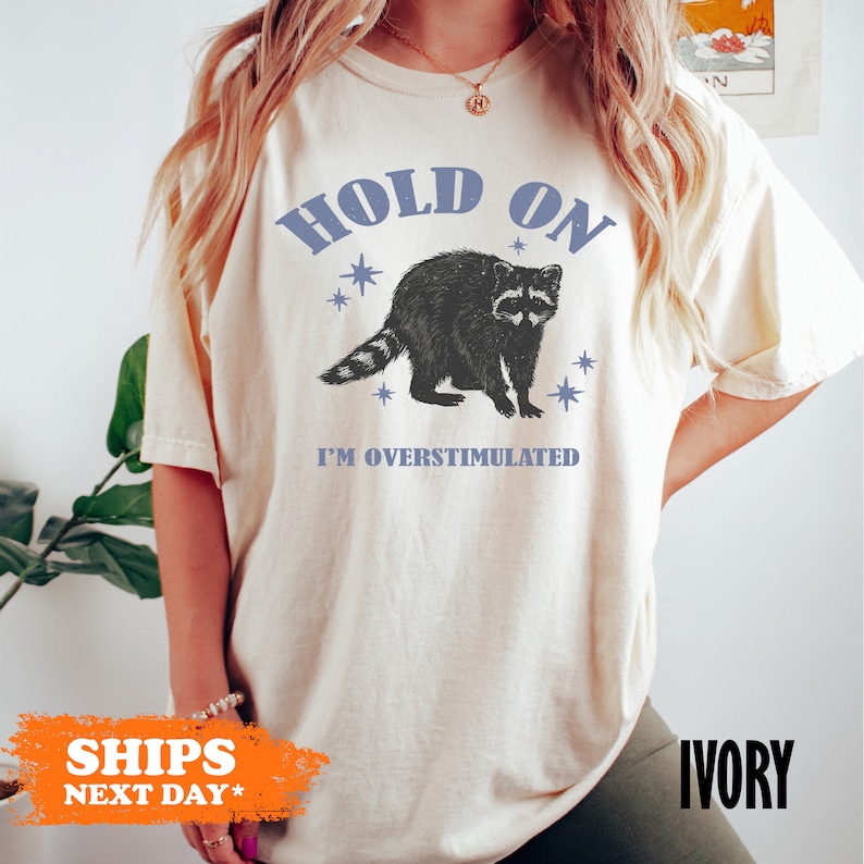 a woman wearing a t - shirt that says hold on i'm oversim