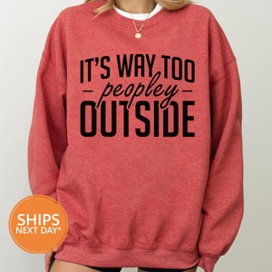 a woman wearing a red sweatshirt that says it's way to people outside