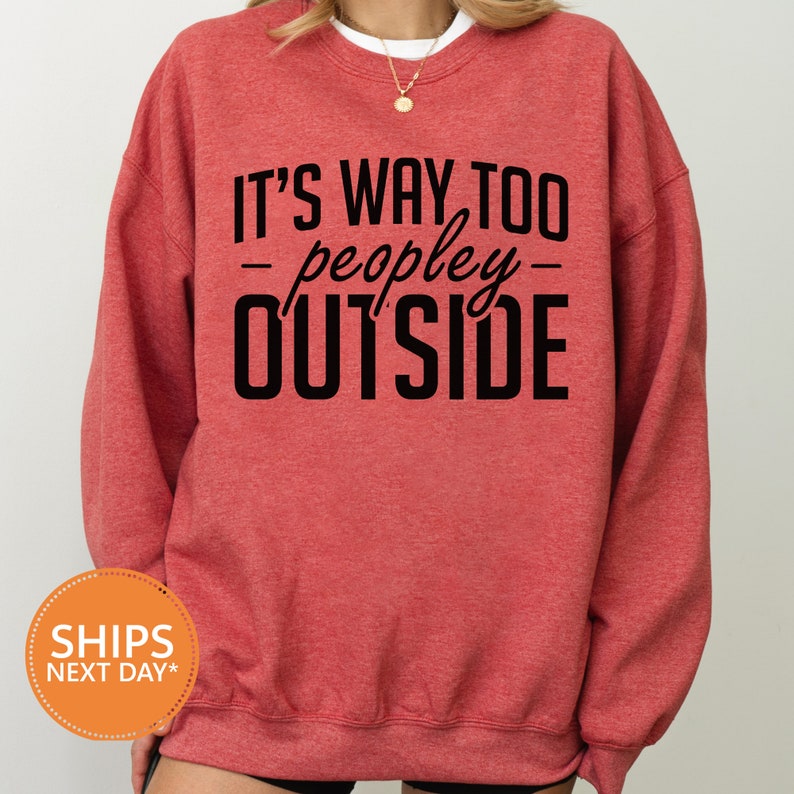 a woman wearing a red sweatshirt that says it's way to people outside