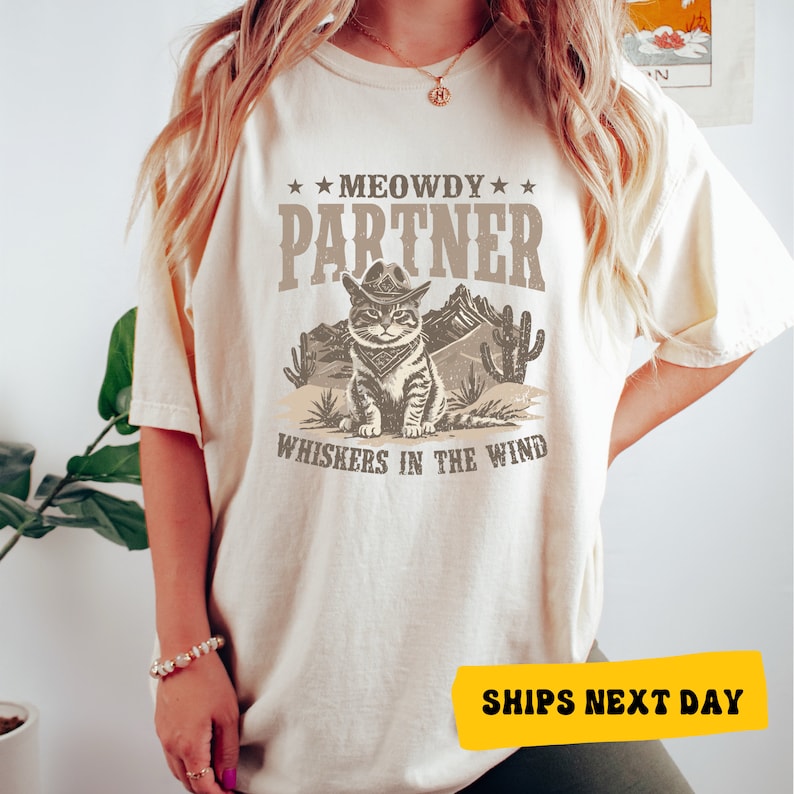 a woman wearing a t - shirt that says meowy partner whiskeys in