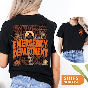 May include: A black t-shirt featuring a large orange graphic on the back with the text EMERGENCY DEPARTMENT, a haunted house, a skeleton hand, a pumpkin, and a tombstone. The front chest area displays a smaller matching emergency medical logo.