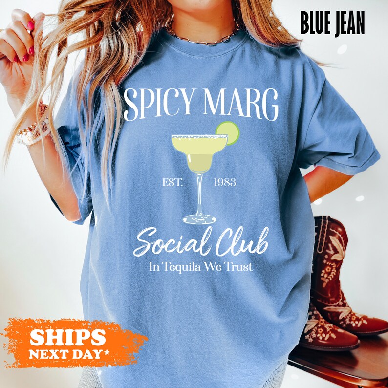 a woman wearing a blue shirt that says spicy marg social club in tequila we