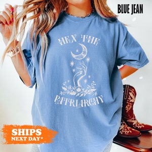 a woman wearing a blue shirt with a crescent moon on it