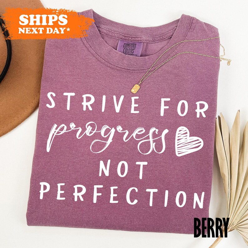 a t - shirt that says strike for progress not perfection