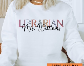 May include: White sweatshirt with the text "LIBRARIAN Mrs. Williams" in colorful letters. The text is in a modern font style.