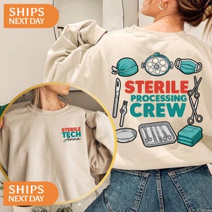 May include: A beige crewneck sweatshirt featuring a back graphic of medical instruments, a surgical light, a cap, and a mask with the text STERILE PROCESSING CREW. The front left chest displays the text STERILE TECH Anna in red and teal lettering.