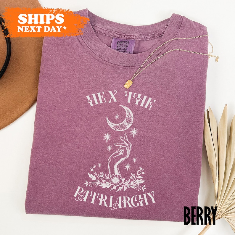 a purple t - shirt with a white graphic on it
