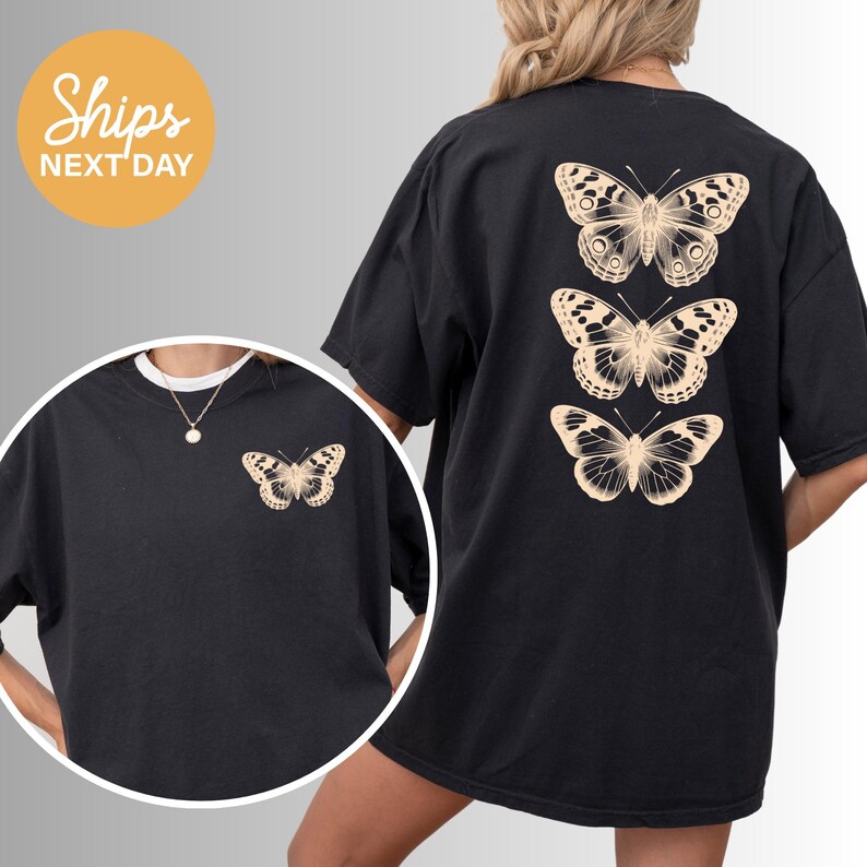 a person wearing a black t-shirt with a design of three butterflies printed on the back.