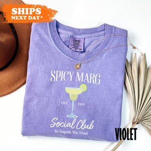 a purple t - shirt with the words spicy marg on it