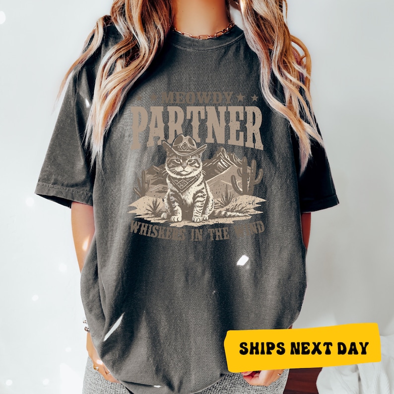 a woman wearing a t - shirt with a picture of a cat on it