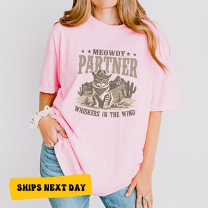 a woman wearing a pink shirt with a cat on it