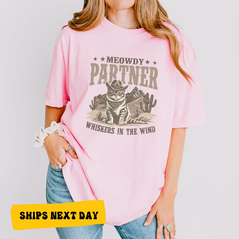 a woman wearing a pink shirt with a cat on it