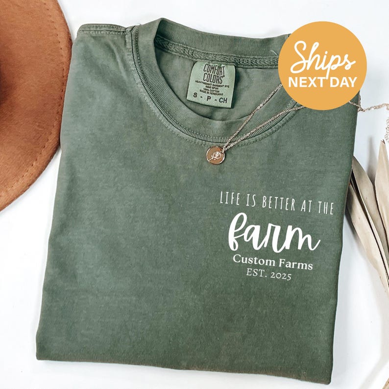 a green t - shirt that says, life is better at the farm custom farms