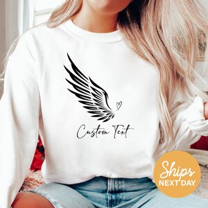a woman wearing a white shirt with a black bird on it