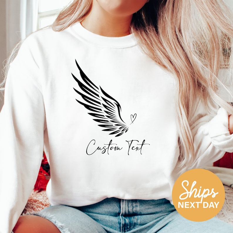 a woman wearing a white shirt with a black bird on it