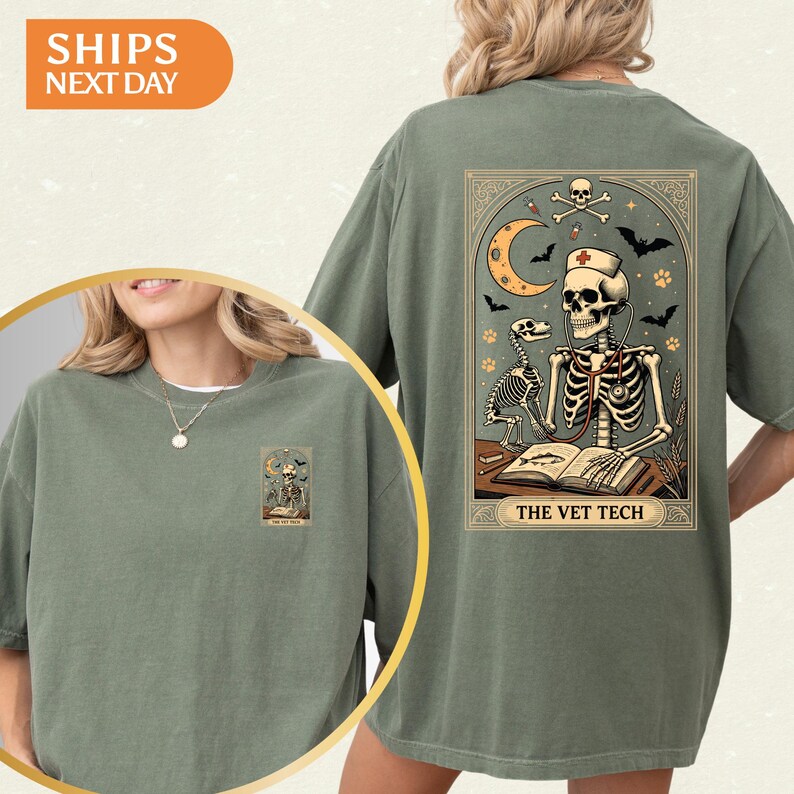 Peut inclure: T-shirt vert sauge avec un motif de carte de tarot au dos, repr&eacute;sentant un technicien v&eacute;t&eacute;rinaire squelette, une lune, des chauves-souris et le texte "THE VET TECH". Une version plus petite du motif est sur le devant.