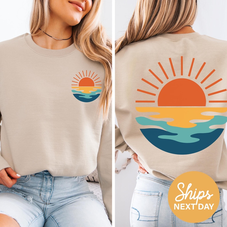 a woman wearing a sweatshirt with a sunset on it