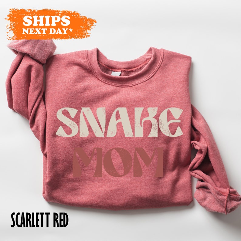 a pink sweater with the words snake mom on it