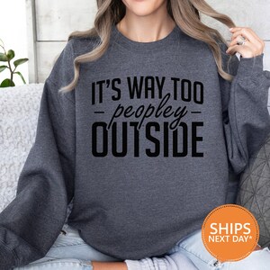 a woman wearing a sweatshirt that says it's way to people outside