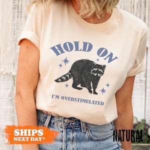 a woman wearing a t - shirt with a raccoon on it