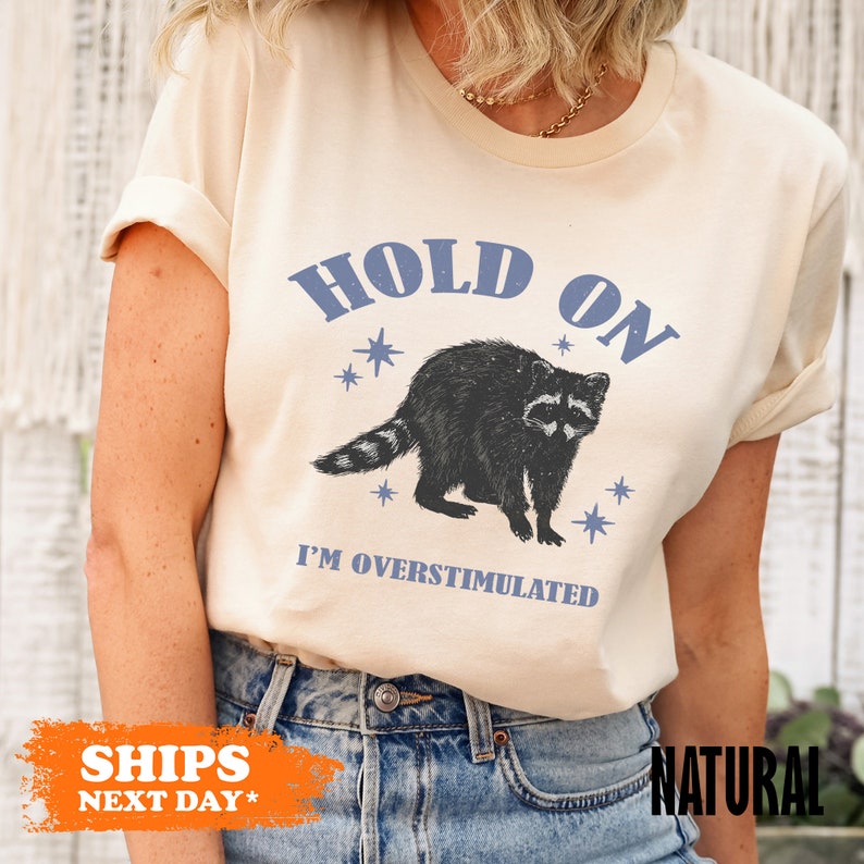 a woman wearing a t - shirt with a raccoon on it