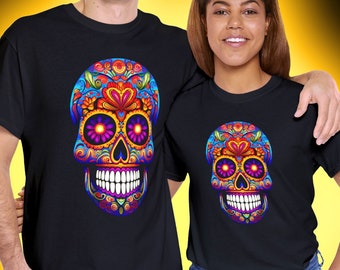May include: Two black t-shirts with a colorful sugar skull design. The skull has pink, blue, yellow, and green details. The text "Pino's Parlor" is in the top right corner of the image.
