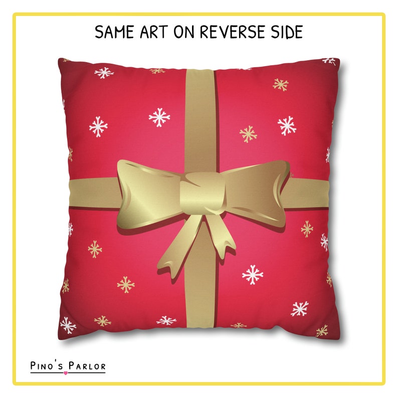 May include: Red throw pillow with a gold bow and ribbon design. The pillow has a white snowflake pattern.