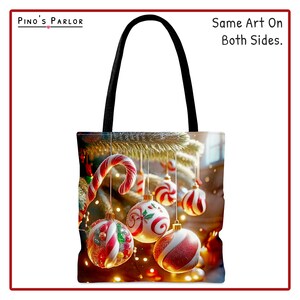 May include: A black tote bag with a Christmas tree design. The bag features red and white candy canes and ornaments hanging from the tree branches. The text "Same Art On Both Sides." is printed on the bag.