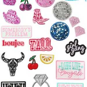 May include: A collection of iron-on patches featuring various designs, including a pink flamingo, a disco ball, a cowboy hat, a cherry, a diamond ring, a lemon, a bull skull, a pair of cowboy boots, a tiger, and the words "Howdy", "Y'all", "Boujee", "Girl Gang", "Somebody's Problem", "Long Live Cowgirls", and "Bride".