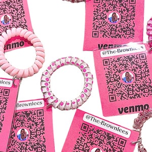 Puede incluir: Gomas para el pelo en espiral de varios colores, incluyendo rosa y transparente, con elementos decorativos. Las gomas se muestran con etiquetas rosas con un código QR, el texto "@The-Brownlees" y la palabra "venmo".