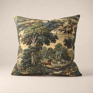 May include: A square throw pillow featuring a detailed tapestry-style print of a lush forest landscape filled with numerous horses in various shades of brown, white, and grey. The scene depicts horses running and grazing among dense green trees.