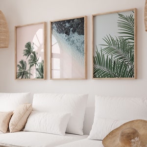 Puede incluir: Un sof&aacute; blanco con tres almohadas y una manta. Tres impresiones enmarcadas de escenas tropicales cuelgan en la pared detr&aacute;s del sof&aacute;. Las impresiones muestran palmeras, olas del oc&eacute;ano y una playa tropical.