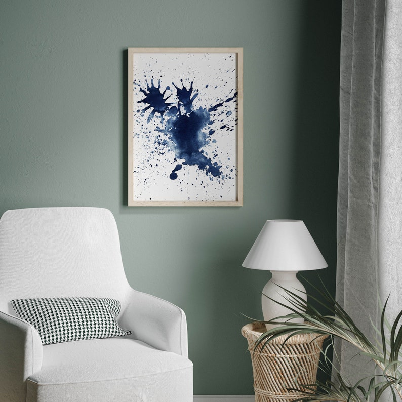Puede incluir: Una pintura abstracta de acuarela enmarcada con un dise&ntilde;o de salpicaduras azules sobre un fondo blanco.