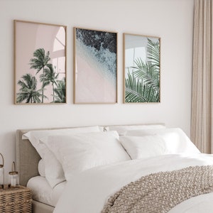 Puede incluir: Tres impresiones enmarcadas con un tema tropical. La primera impresi&oacute;n presenta palmeras contra un cielo rosa. La segunda impresi&oacute;n muestra una escena de playa con olas rompiendo en la orilla. La tercera impresi&oacute;n presenta un primer plano de hojas de palma.
