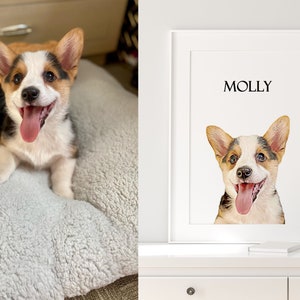 Op de afbeelding: Een witte ingelijste print met de naam "MOLLY" bovenaan en een aquarel van een corgi-hond met bruin, wit en zwart haar. De hond kijkt met zijn tong naar buiten naar de camera.