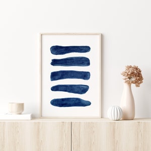 Puede incluir: Una impresi&oacute;n enmarcada con un dise&ntilde;o minimalista que presenta cinco pinceladas azules horizontales sobre un fondo blanco.