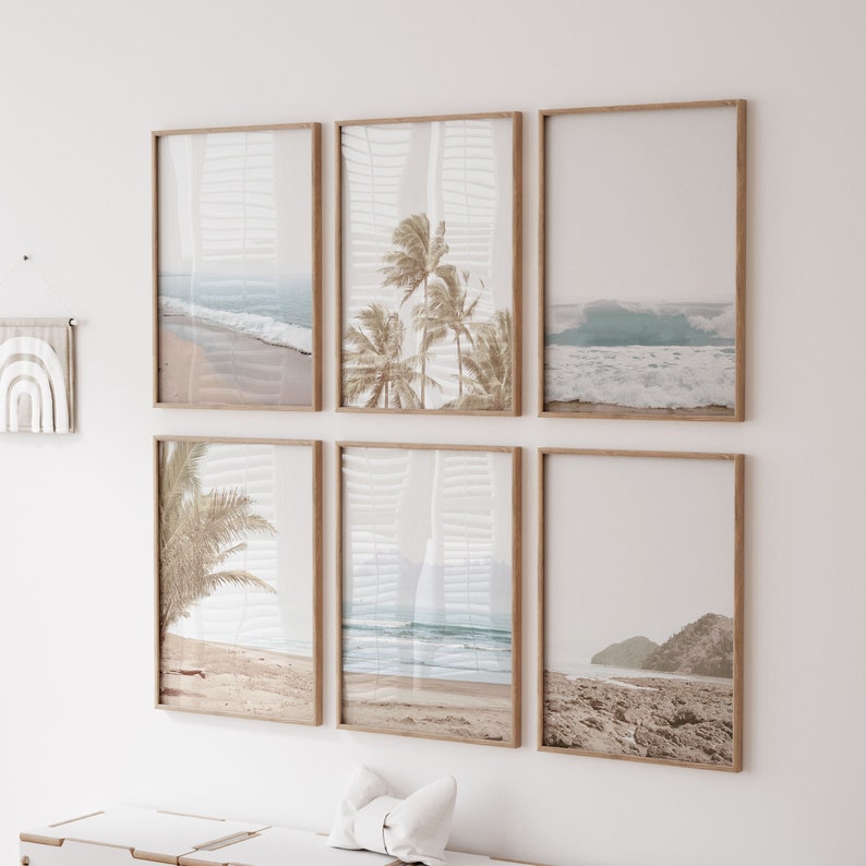 May include: A set of six framed prints featuring beach scenes with palm trees, waves, and sandy shores. The prints are in a light wood frame and are arranged in a grid pattern on a white wall.