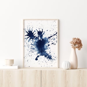 Puede incluir: Una impresi&oacute;n de acuarela abstracta enmarcada con un dise&ntilde;o de salpicaduras azules sobre un fondo blanco.