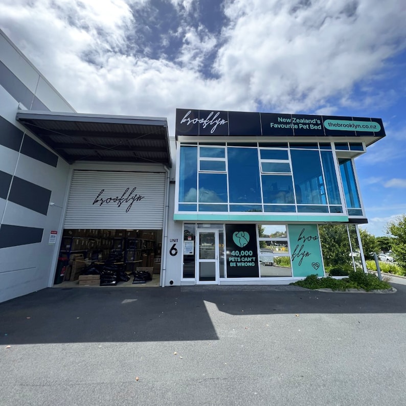 May include: Exterior view of a business with a sign that reads "brooklyn New Zealand's Favourite Pet Bed thebrooklyn.co.nz". The business has a large glass storefront and a sign that says "40,000 Pets Can't Be Wrong".