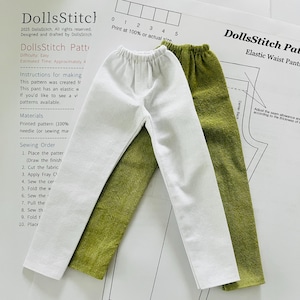 以下が含まれることがあります： 白いパンツとオリーブグリーンの人形用ゴムウエストパンツが2組、型紙の上に置かれています。白いパンツは緑色のパンツの上にあります。型紙には「DollsStitch」と「Elastic Waist Pants」と書かれています。