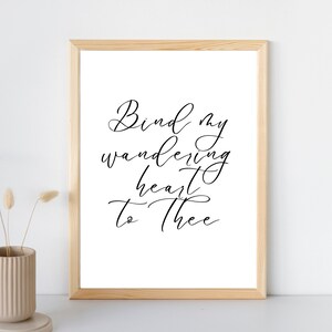 May include: Black and white printable wall art with the text "Bind my wandering heart to thee" in a cursive font.