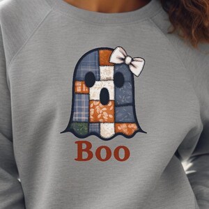 May include: A gray sweatshirt featuring a patchwork ghost design with a white bow. The ghost is made of various fabric patterns in blue, orange, and brown. The word "Boo" is printed in red below the ghost. Text at the top reads "EXAMPLES OF PROJECT APPLICATIONS".