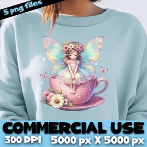 Peut inclure: Un sweat-shirt bleu clair avec une illustration de fée. La fée, avec des ailes irisées et une couronne de fleurs, est assise dans une tasse à thé rose. La tasse à thé est ornée de fleurs. Le texte en bas indique "COMMERCIAL USE" et "300 DPI 5000 px X 5000 px".