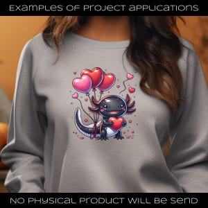 Puede incluir: Una sudadera gris con un ajolote de dibujos animados sosteniendo un coraz&oacute;n y globos en forma de coraz&oacute;n. El ajolote es negro con detalles rosas. El texto en la parte superior dice "EXAMPLES OF PROJECT APPLICATIONS" y el texto en la parte inferior dice "NO PHYSICAL PRODUCT WILL BE SEND".