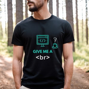 May include: Black t-shirt with a teal graphic of a computer monitor, a question mark, and a coffee cup. The text "GIVE ME A <br>" is printed below the graphics. The shirt is being worn outdoors.
