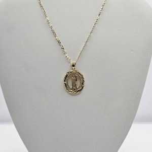 May include: A gold chain necklace with a round pendant featuring a detailed image of the Virgin Mary.