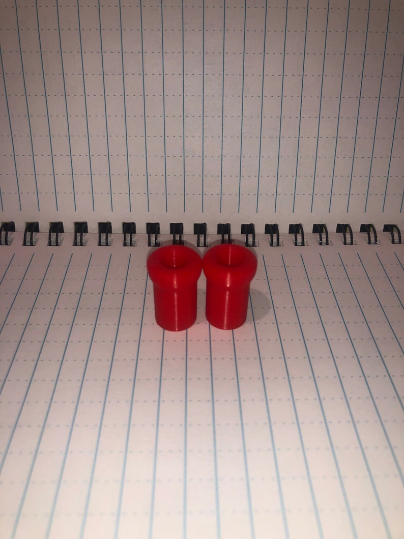 Peut inclure: Deux bouchons de bouteille en plastique rouge. Les bouchons sont cylindriques avec un sommet l&eacute;g&egrave;rement &eacute;vas&eacute;.