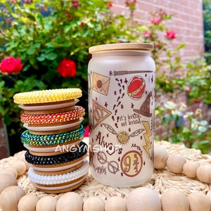 May include: A stack of colorful rhinestone bracelets with a white frosted glass jar with a bamboo lid. The jar has a Harry Potter themed design with the words "Always" and "9 3/4" printed on it.